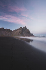 sunset on the beach with black sand and mountains