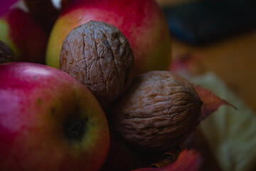 Close up macro shot of walnuts. Autumn natural scene with bunch of apples and yellow leaves 