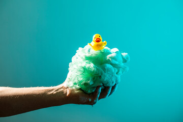 Funny photo. Rubber duck in the hands of an adult. Bath. 
