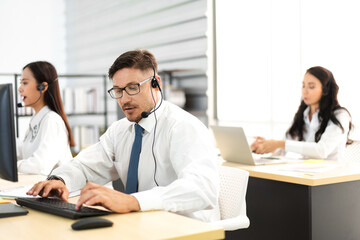 Obraz premium Group of happy call center smiling business operator customer support team phone services agen working and talking with headset on desktop computer at call center