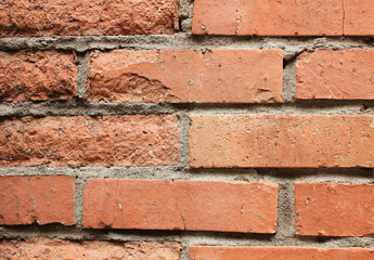 A wall of partially damaged red bricks. Industrial background