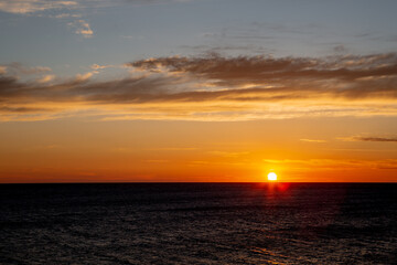 The sun sets over the sea at sunset