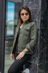 Young Beautiful Asian Woman Wearing Jacket And Black Jeans Posing Outdoors