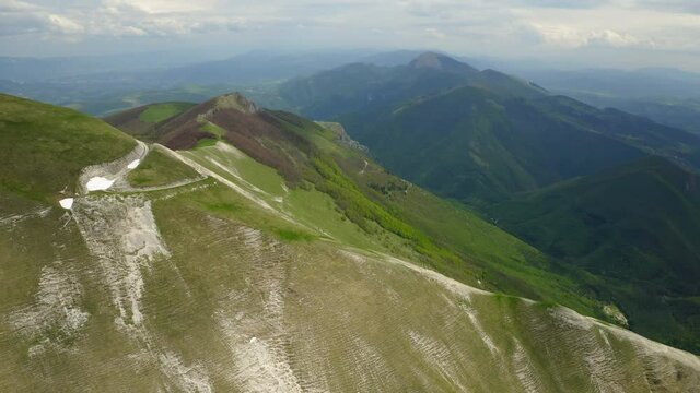 Aerial Growth Of Green Plants On Mountains, Drone Flying Backwards Against Clouds Sky - Apennine Mountains, Italy