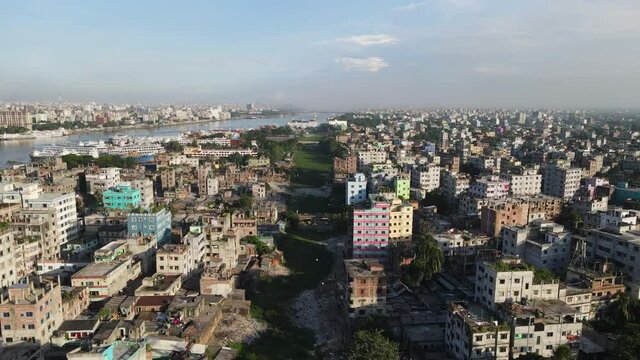 Aerial across urban Dhaka city showing dry canal used as industrial garbage dump