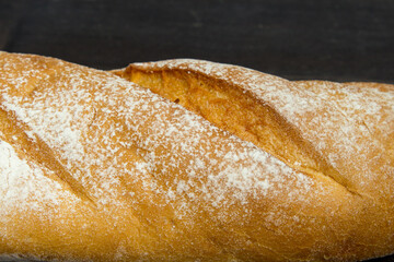 Baguette. Fresh golden baguette on an old wooden table. Close-up. French traditional bread on a dark background. Top view. Copy space. - 467827182