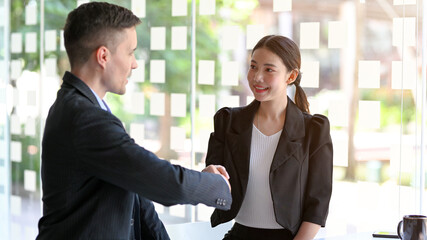 Caucasian businessman hand shaking with asian businesswoman