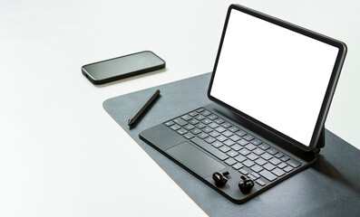 blank screen portable tablet with magic keyboard and gadget on white table.