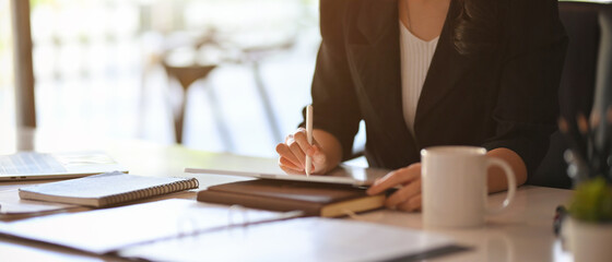 Executive female boss in the meeting, working on digital tablet computer