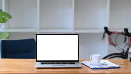 Mock up computer laptop, coffee cup and documents on wooden table.