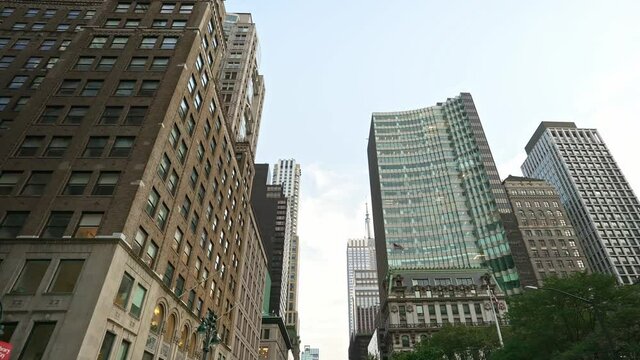 Establishing moving shot of skyscrapers buildings street in New York City Manhattan. 4k slow motion. American modern urban lifestyle, work in the city, NYC.