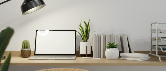 Cozy minimalist computer workspace with laptop computer mockup on wooden desk