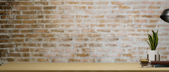 Mockup space on wooden table with stuff over vintage brick wall background.