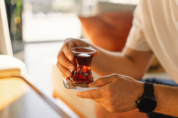 A man drinks Turkish traditional hot tea in the lobby of a Turkish hotel. Turkish tea and...