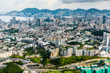 Fototapeta premium Panorama aerial view of Hong Kong Kowloon's crowded buildings and Victoria Harbour in China.