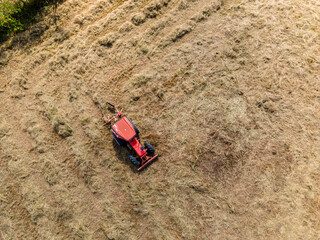 Aerial view of Agriculture tractor harvesting pangola grass in farm, animal feed
