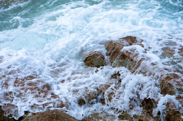 Waves crushing into the rocks. Bubble sea waves hit the rocks. (Koh Lipe, Thailand)