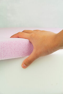 the hand presses on the surface of the rubber foam. Checking hardness and softness. Choosing the best type and quality. Close-up.