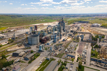 Aerial view of cement plant with high concrete factory structure and tower crane at industrial...
