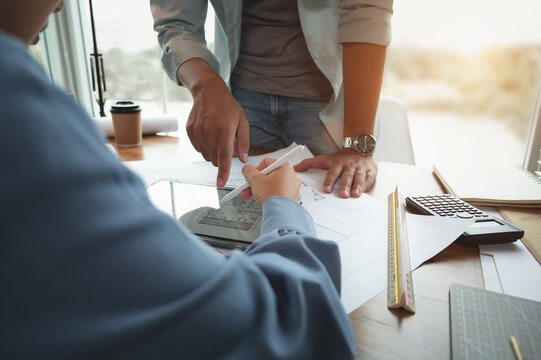 Architects and interior designers women discussing to concept of building design. Estimation for construction project with tablet technology, Drawing, Material and Model. Selective focus center image