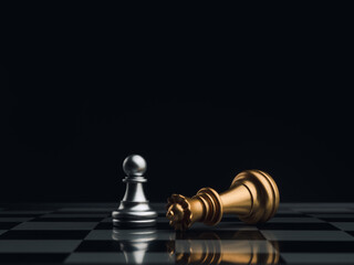 Obraz na płótnie Canvas A little silver pawn chess piece standing with the win near a fallen golden queen chess piece on a chessboard on dark background. Leadership, winner, brave, competition, and business strategy concept.