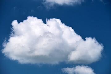Bright landscape of white puffy cumulus clouds on blue clear sky