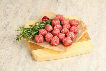 Raw uncooked beef meatballs served rosemary