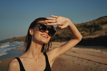 woman on the beach in sunglasses in a swimsuit sun