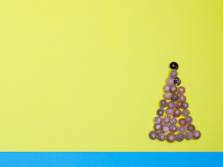 Creative Christmas tree made of various decorative seashells on modern yellow blue paper...