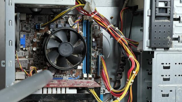 master of the service center cleans the system unit with a vacuum cleaner, close-up.