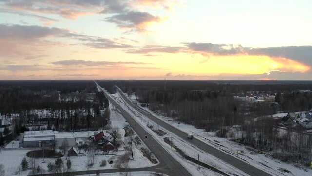 Push-in drone shoot above dual lane highway. Chasing a white semi truck during golden hour.