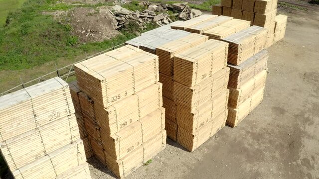Drone shoot of stacked wood material - flight up, pan down creating an arch.