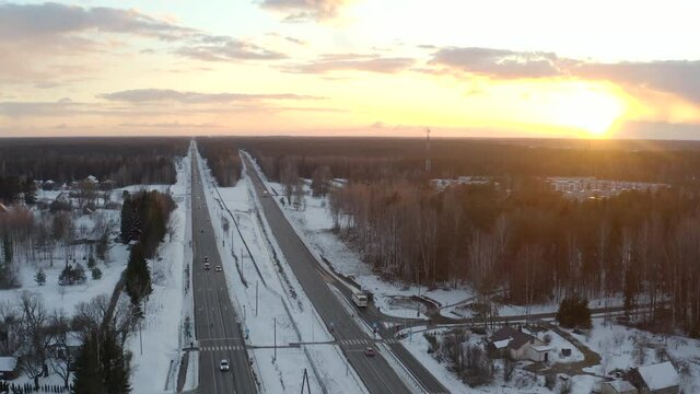 Pull back shoot above a highway. Golden hour, low traffic winter evening.