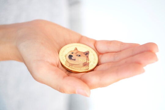 Maesot, Thailand- June 5, 2021:Hand holding a Doge coin or cryptocurrencies coin. Concept of blockchain system crisis.