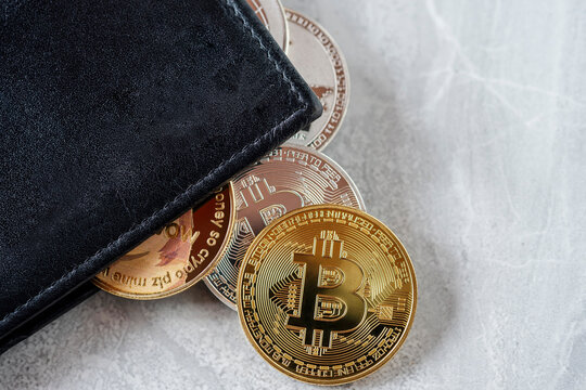 Maesot, Thailand- June 5, 2021:Symbolic piles of various cryptocurrencies with wallet on the marble floor. Concept of blockchain system crisis.