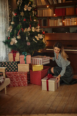 Woman near Christmas tree taking her gift