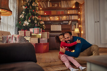 Mixed race girl hugging her father at home