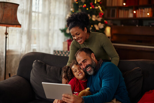 Family gathered on sofa, using a tablet