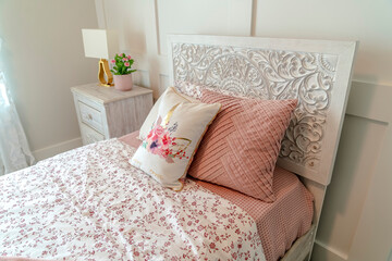 Feminine single bed with decorative headboard floral blaket and pink bedsheet