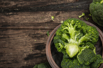 Green fresh broccoli on old wooden background. Ripe vegetables for diet and healthy eating