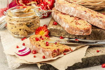 Fresh homemade chicken liver pate or paste in a glass jar with baguette slices on the serving board