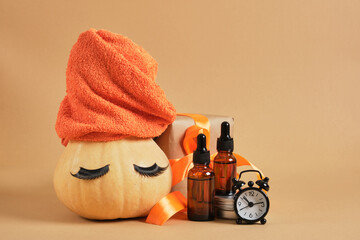 pumpkin with towel and false eyelashes, amber glass dropper bottles, gift box with ribbon and alarm clock