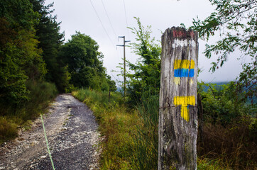 Indicazioni per la Via di Francesco pitturate su un palo di legno
