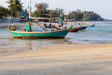 Naklejka na ściany i meble Multi colored fishing boats floating on the seashore