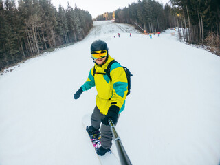 man taking selfie riding on snowboard