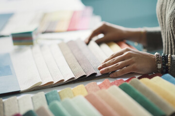 Woman selecting fabric swatches hands close up