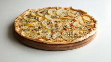 Pizza with cheese and pear fruit on cutting board