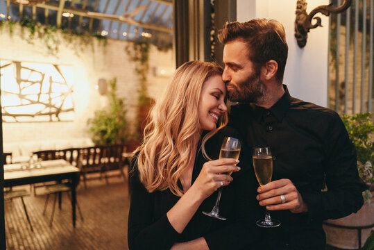 Affectionate man kissing his wife on her forehead at a luxury ho