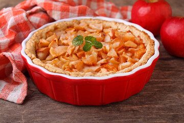 Apple pie in a round shape on a dark background. Traditional American pastries.