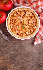 Apple pie in a round shape on a dark background, top view, copy space. Traditional American pastries.
